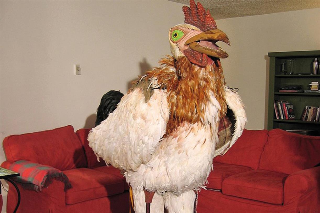 Higher quality photo of the subservient chicken costume. It's creepy… a fleshy face, little teeth on the beak, a cocks comb, and real feathers.